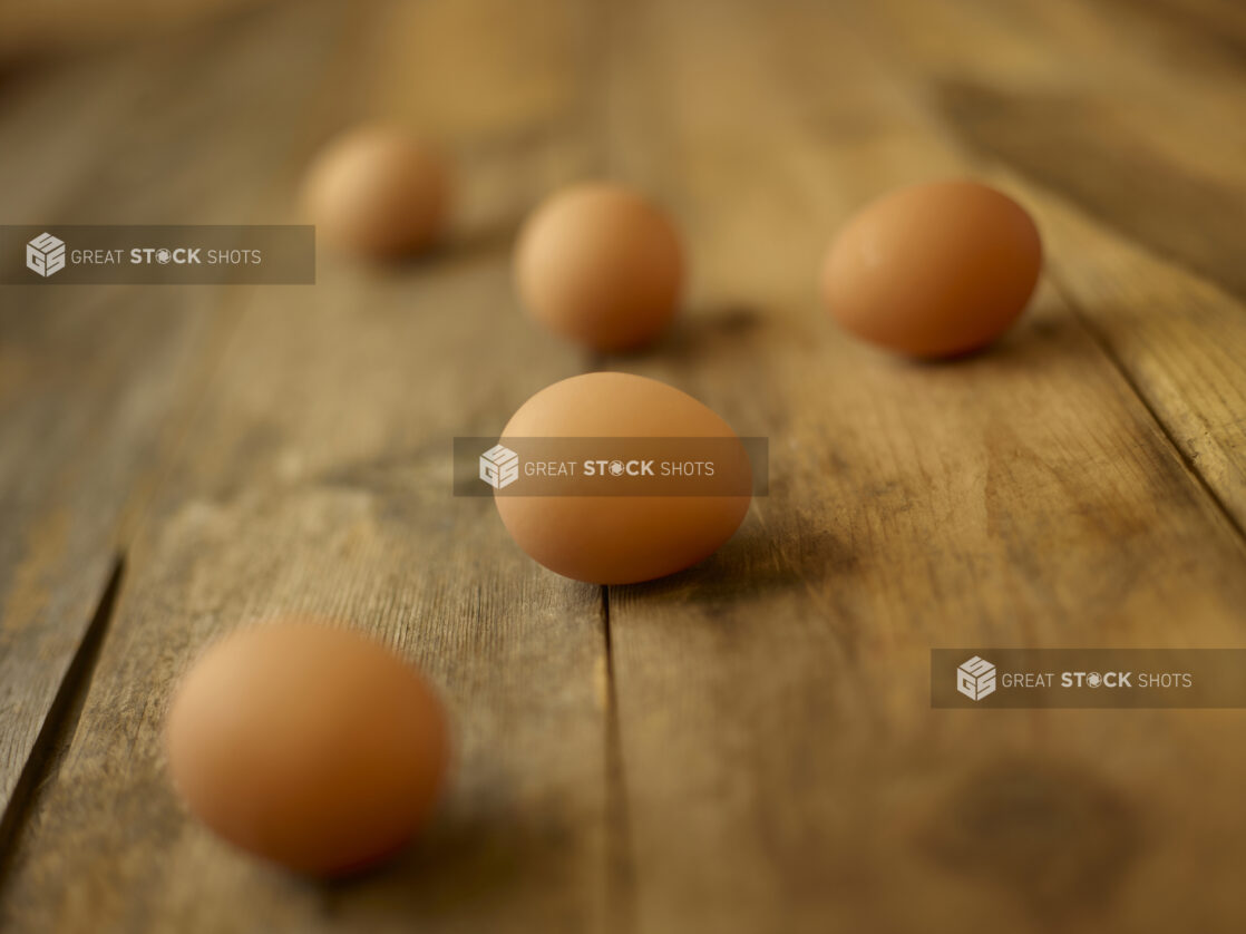 5 whole brown eggs on a rustic wooden table