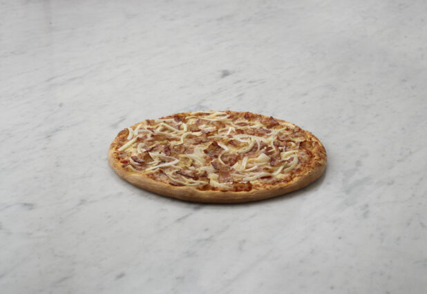 2 topping onion and bacon pizza on a white marble table, straight on view