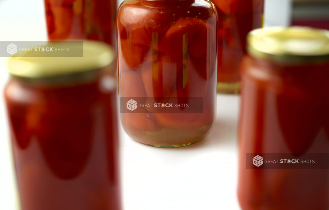 Jars of red peppers preserved in oil, close-up