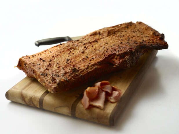 a cut in half sandwich sitting on top of a wooden cutting board