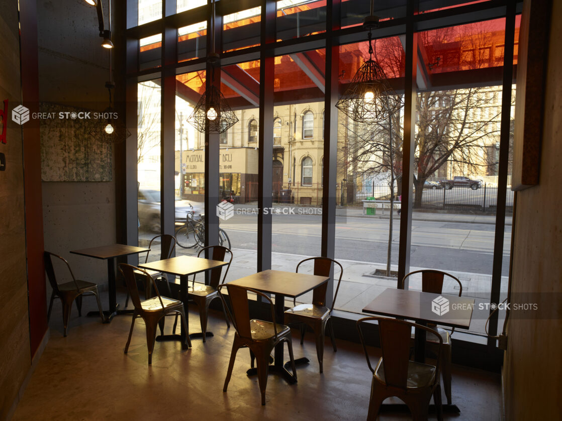 Interior of a restaurant with tables in front of a window