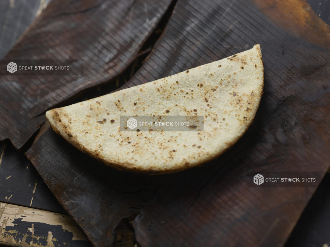 Wood fire pizza crust folded in half on a dark background