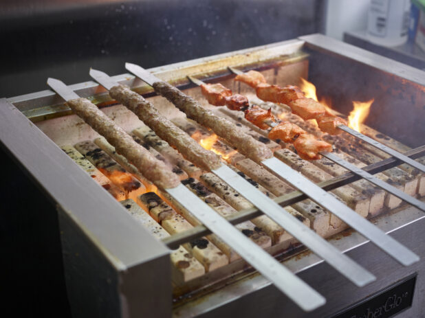 Skewered middle eastern meat roasting over an open flame