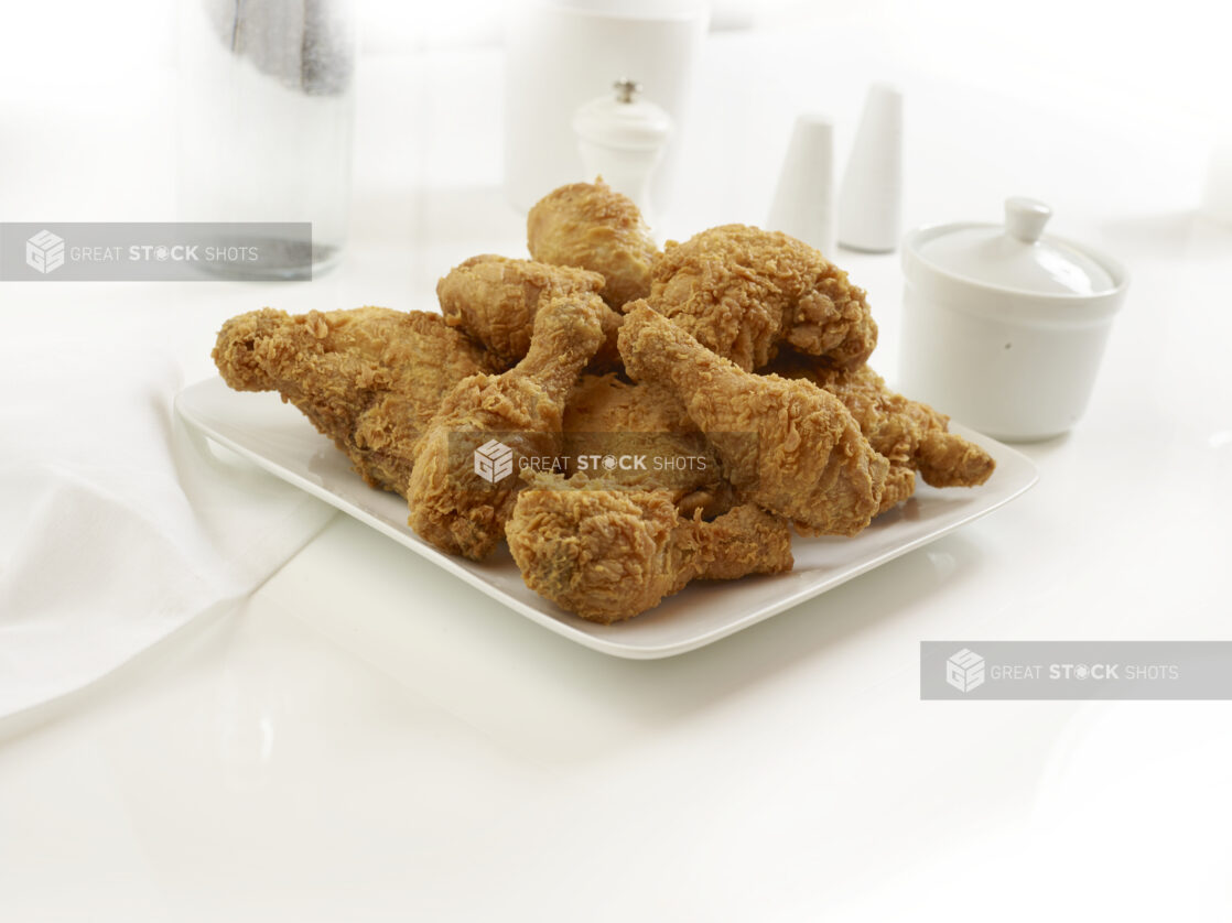 Plated of golden fried chicken pieces on a white background