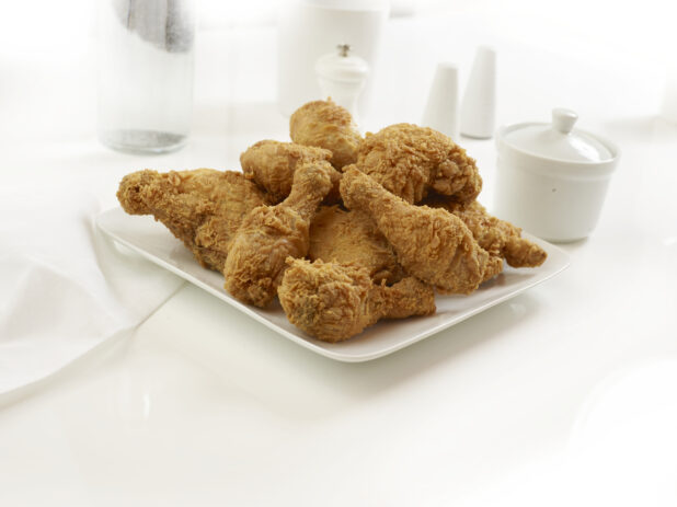 Plated of golden fried chicken pieces on a white background