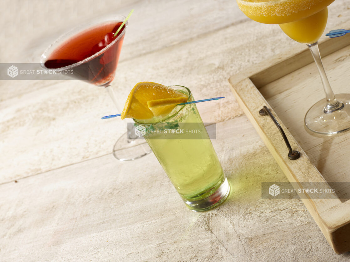 Highball cocktail with a cosmo martini and blended tropical margarita on a wooden background