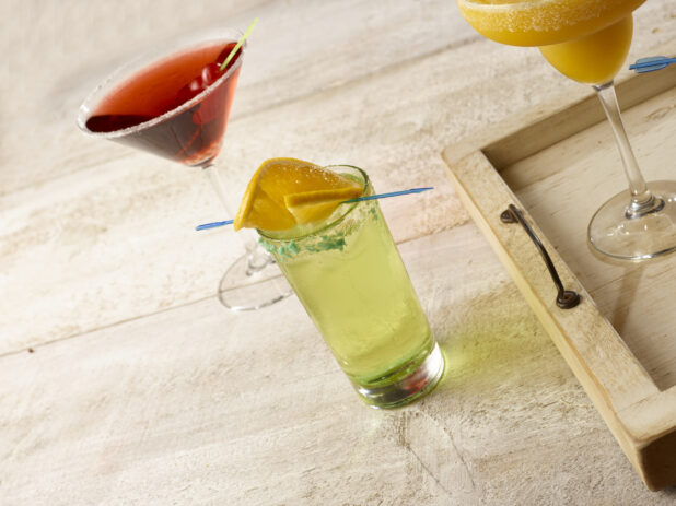 Highball cocktail with a cosmo martini and blended tropical margarita on a wooden background