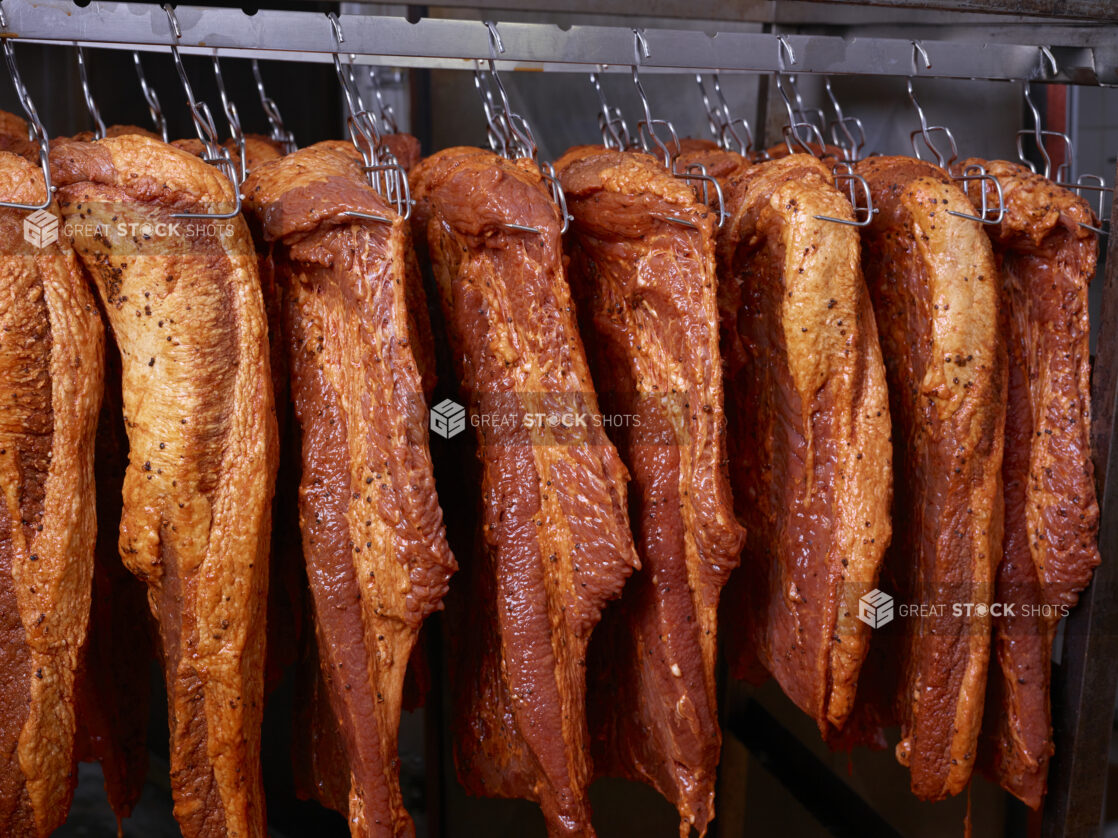 Pastrami hanging in a smoker in a restaurant