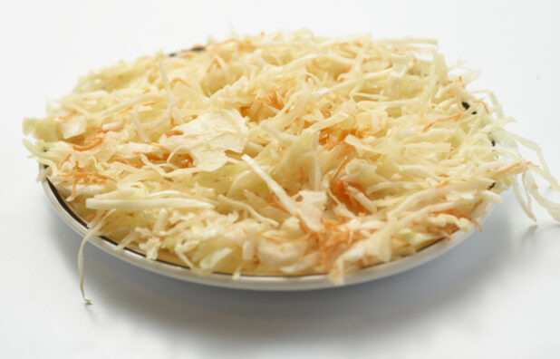 Plate of vinaigrette coleslaw on a white background