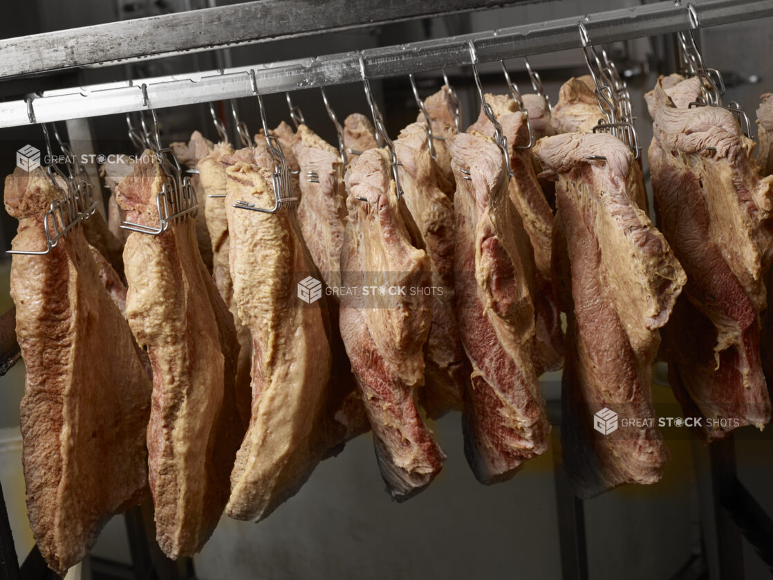 Guanciale curing on meat hooks