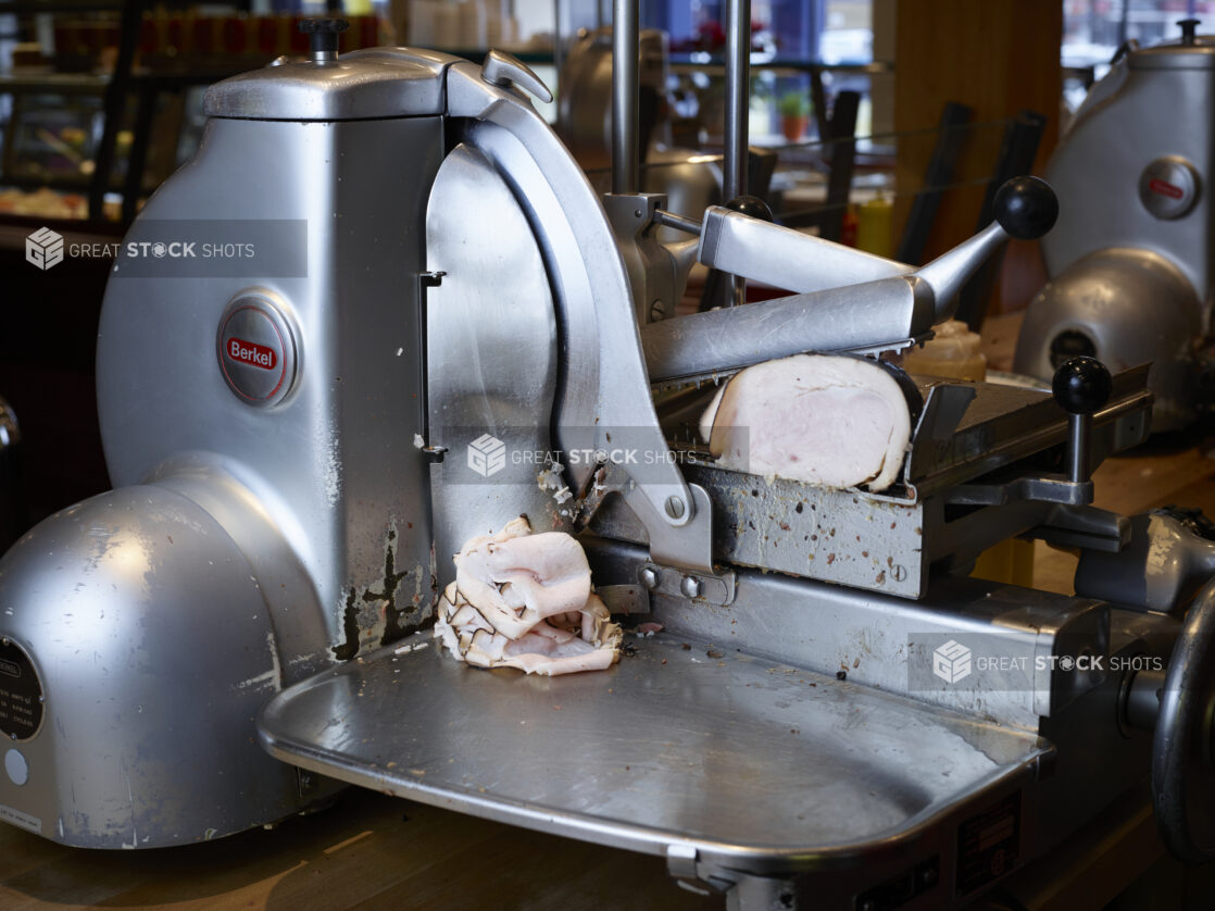 Side view of oven roasted turkey in commercial grade meat slicer