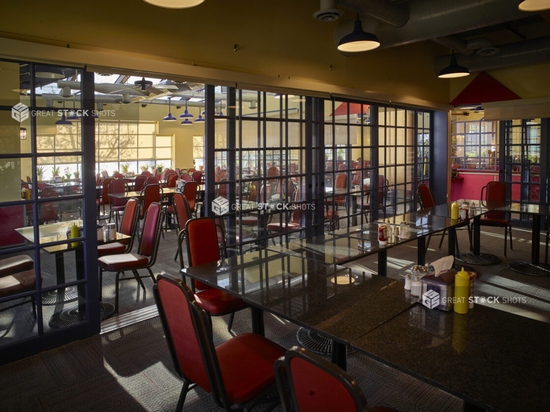 Large empty restaurant with red chairs and sectioned off rooms