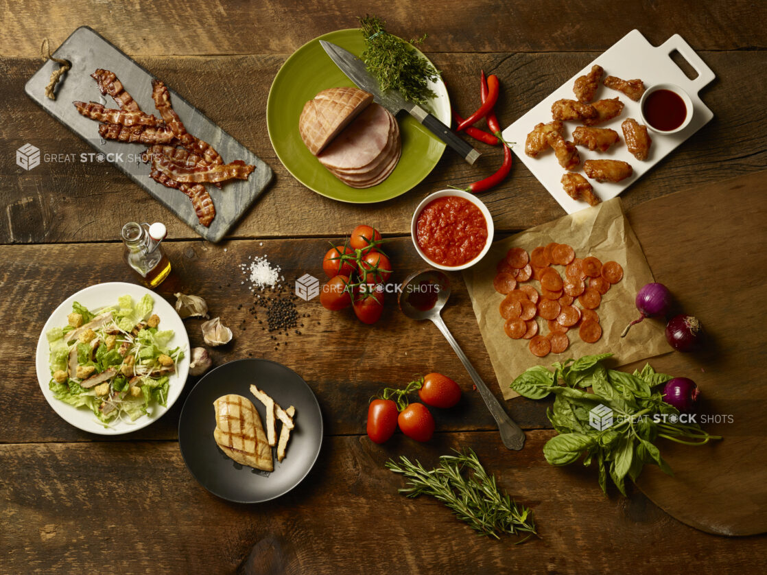 Fresh pizza ingredients and appetizers on a wooden background, overhead