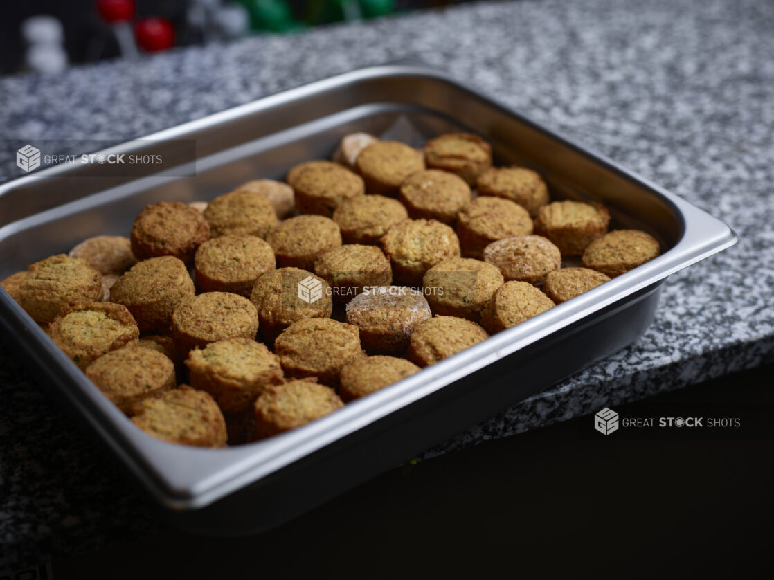 Metal tray of falafels on marble counter