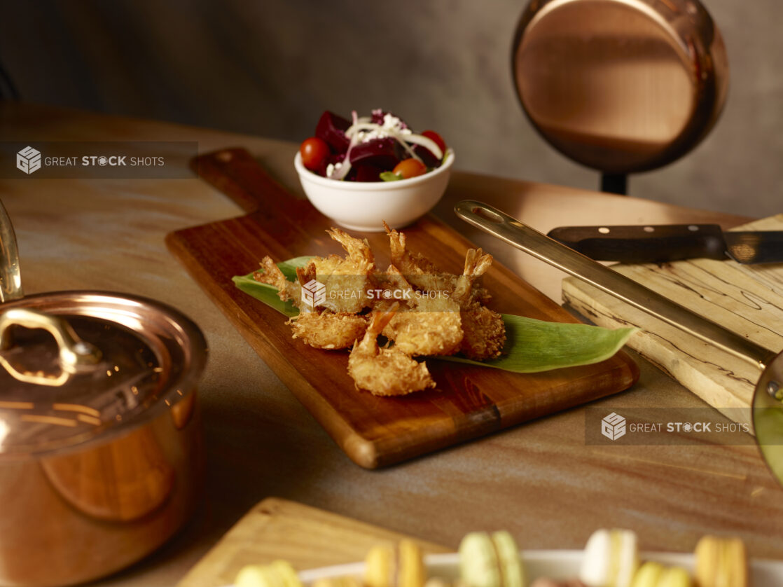 Coconut shrimp on a wooden board with a side beet salad