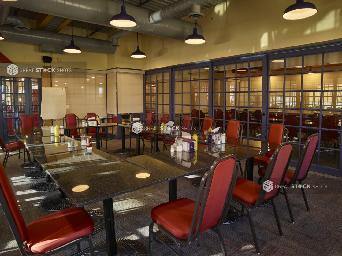 Large empty meeting space in a restaurant with red chairs in a private room