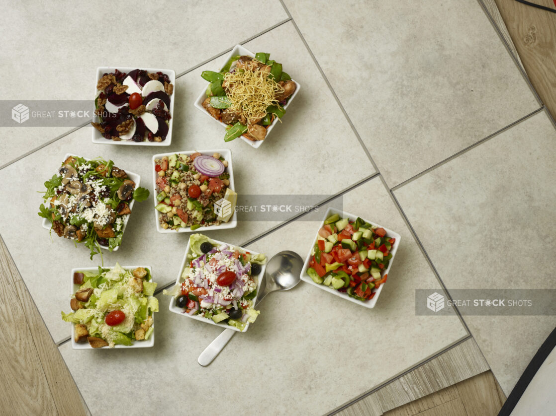 Various vegetarian salads overhead on a tile background