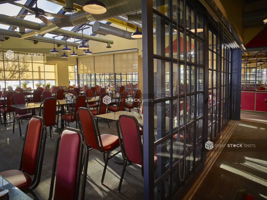 Large empty restaurant with red chairs and sectioned off rooms