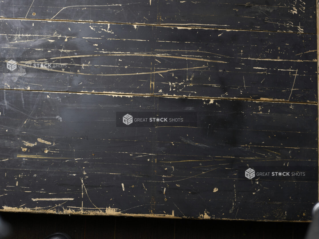 Overhead view of distressed black painted wooden boards