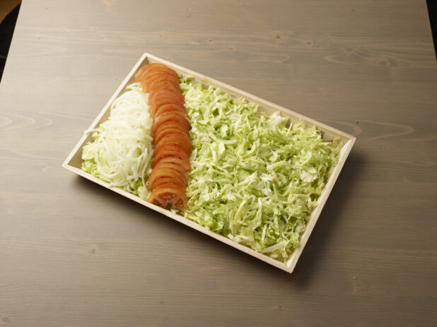 Wooden tray with toppings for kebab or shawarma platter components on a wooden background