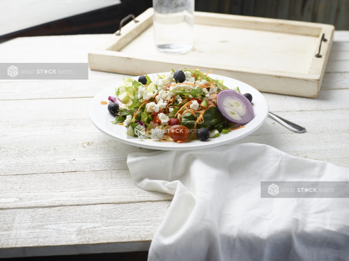 Bow of greek salad on a wooden background