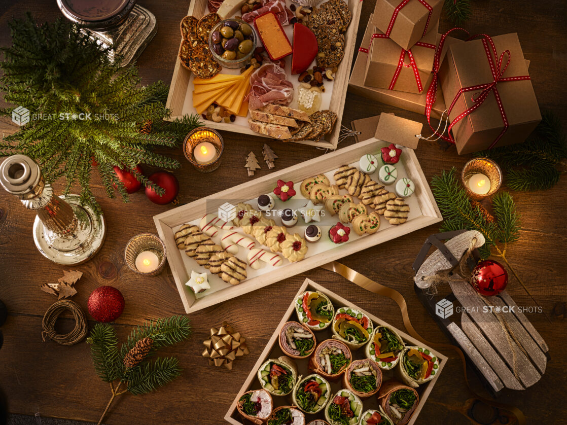 overhead view of charcuterie, cookie and wraps on a wooden platter with holiday decorations