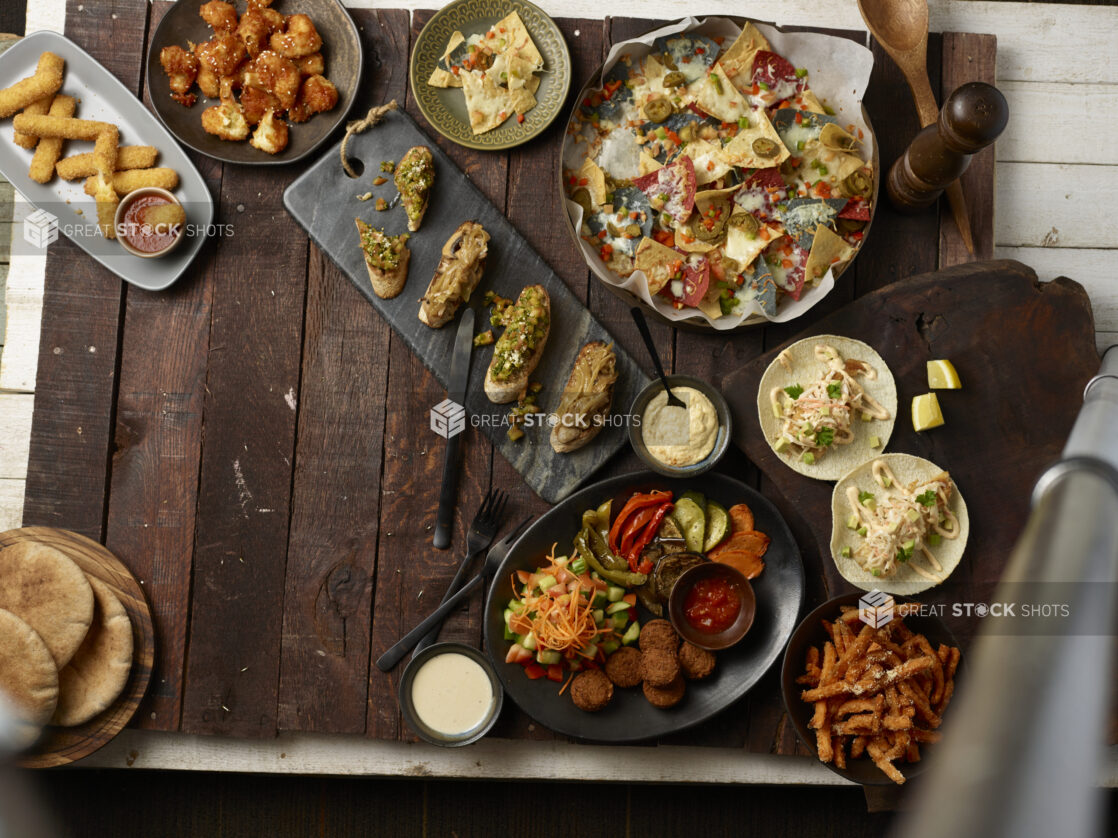 Various plated appetizers on a dark wooden background