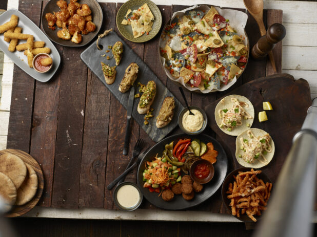 Various plated appetizers on a dark wooden background