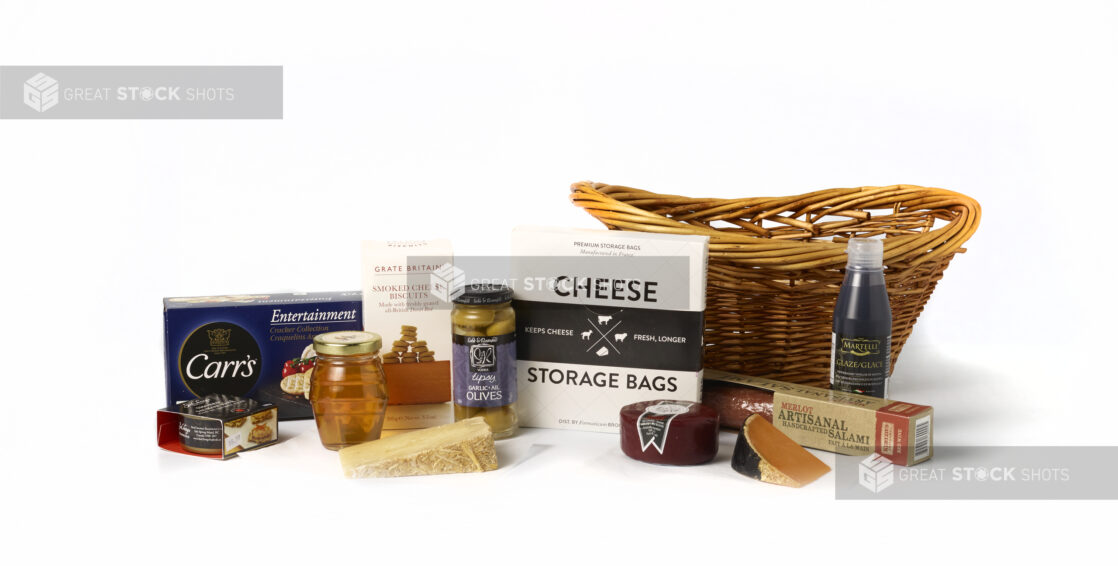 Collection of artisanal products in front of a wicker basket on a white background