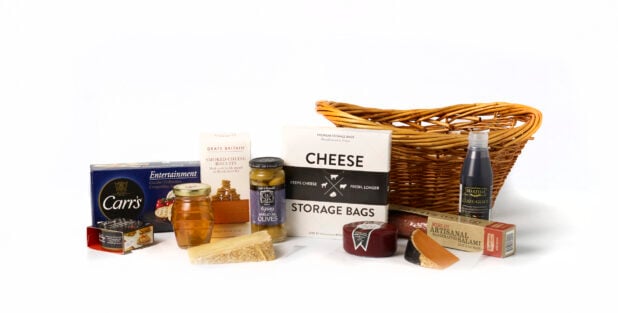 Collection of artisanal products in front of a wicker basket on a white background