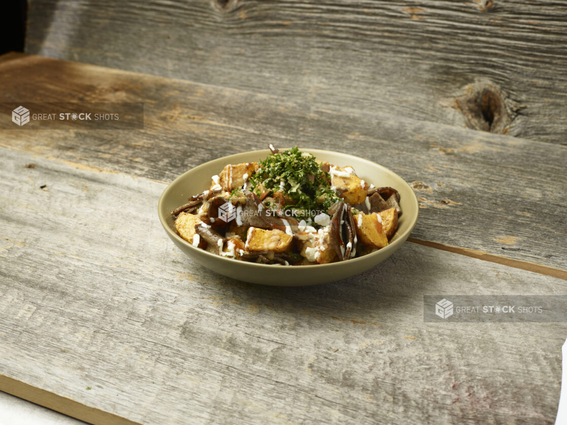 Gyros potato bowl on an aged wooden table and background