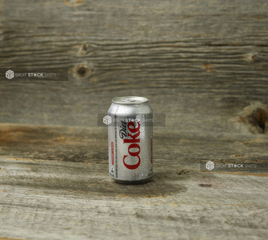 Diet Coke can on a wooden table with a wooden background with a straight on view