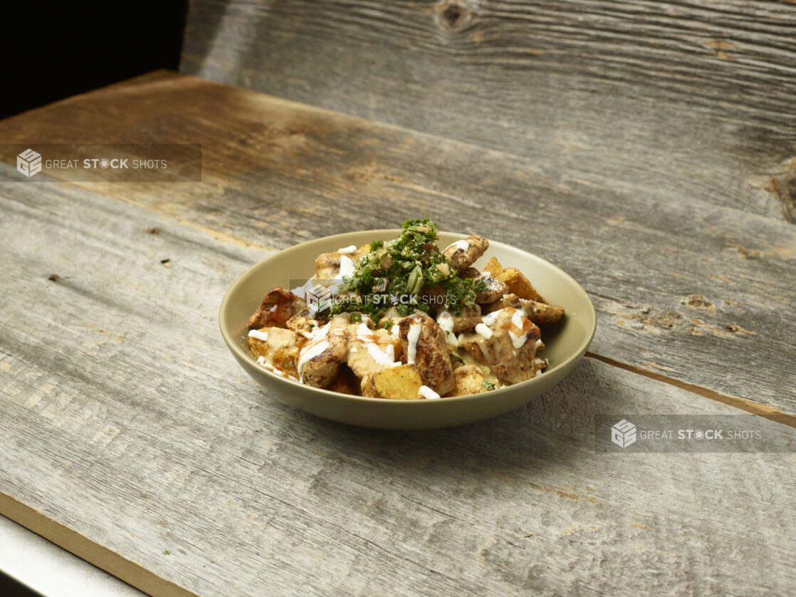 Chicken shawarma potato bowl on an aged wooden table