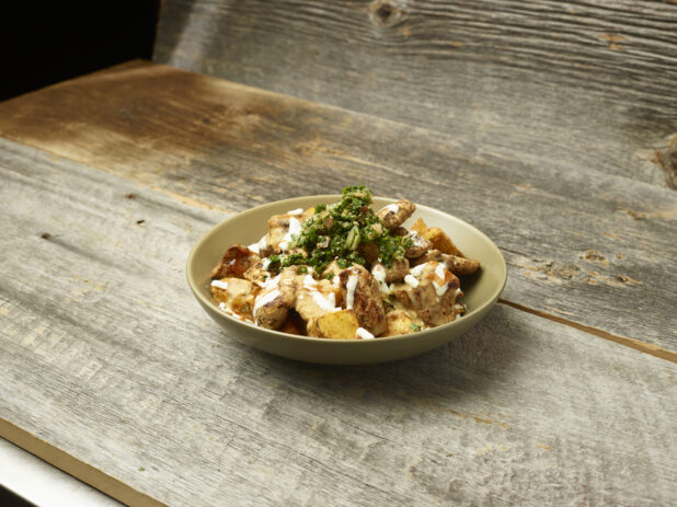 Chicken shawarma potato bowl on an aged wooden table