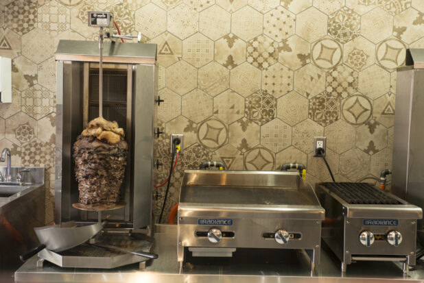 Restaurant kitchen with vertical broiler, grill, flat top and sink
