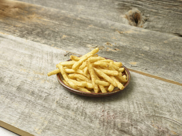 French fries on a plate on an aged wooden table