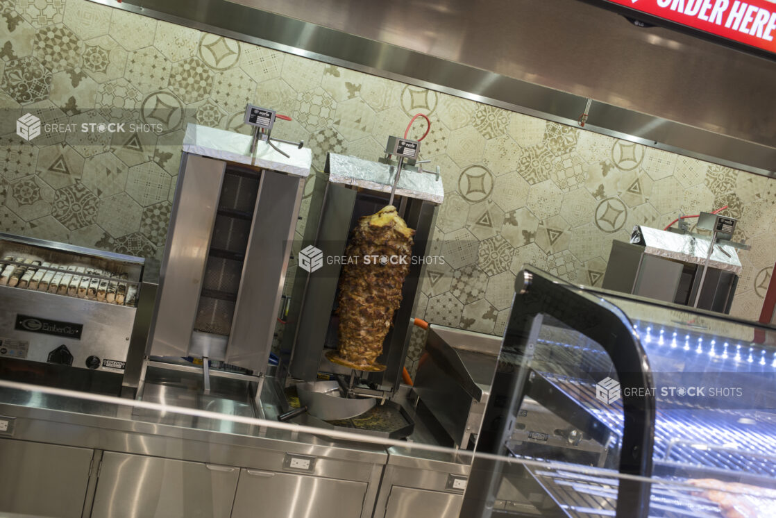 Interior of restaurant with vertical broiler and grill, stainless steel kitchen equipment