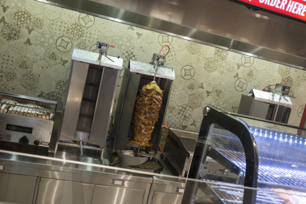 Interior of restaurant with vertical broiler and grill, stainless steel kitchen equipment