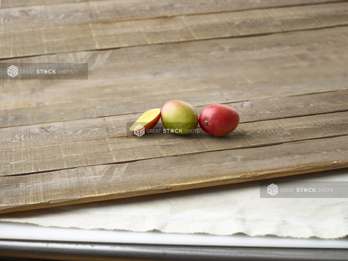 Fresh mangoes on aged wooden planks