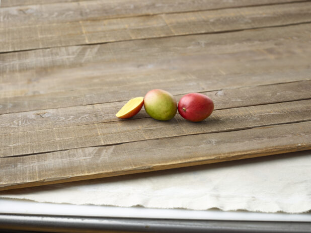 Fresh mangoes on aged wooden planks