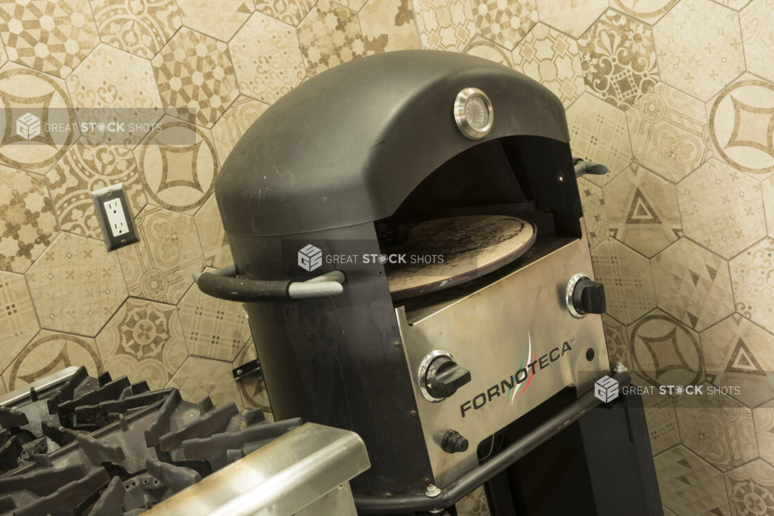 Pizza oven and gas range in restaurant kitchen