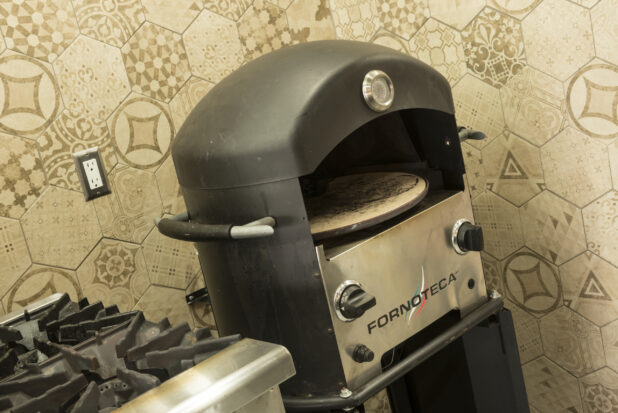 Pizza oven and gas range in restaurant kitchen
