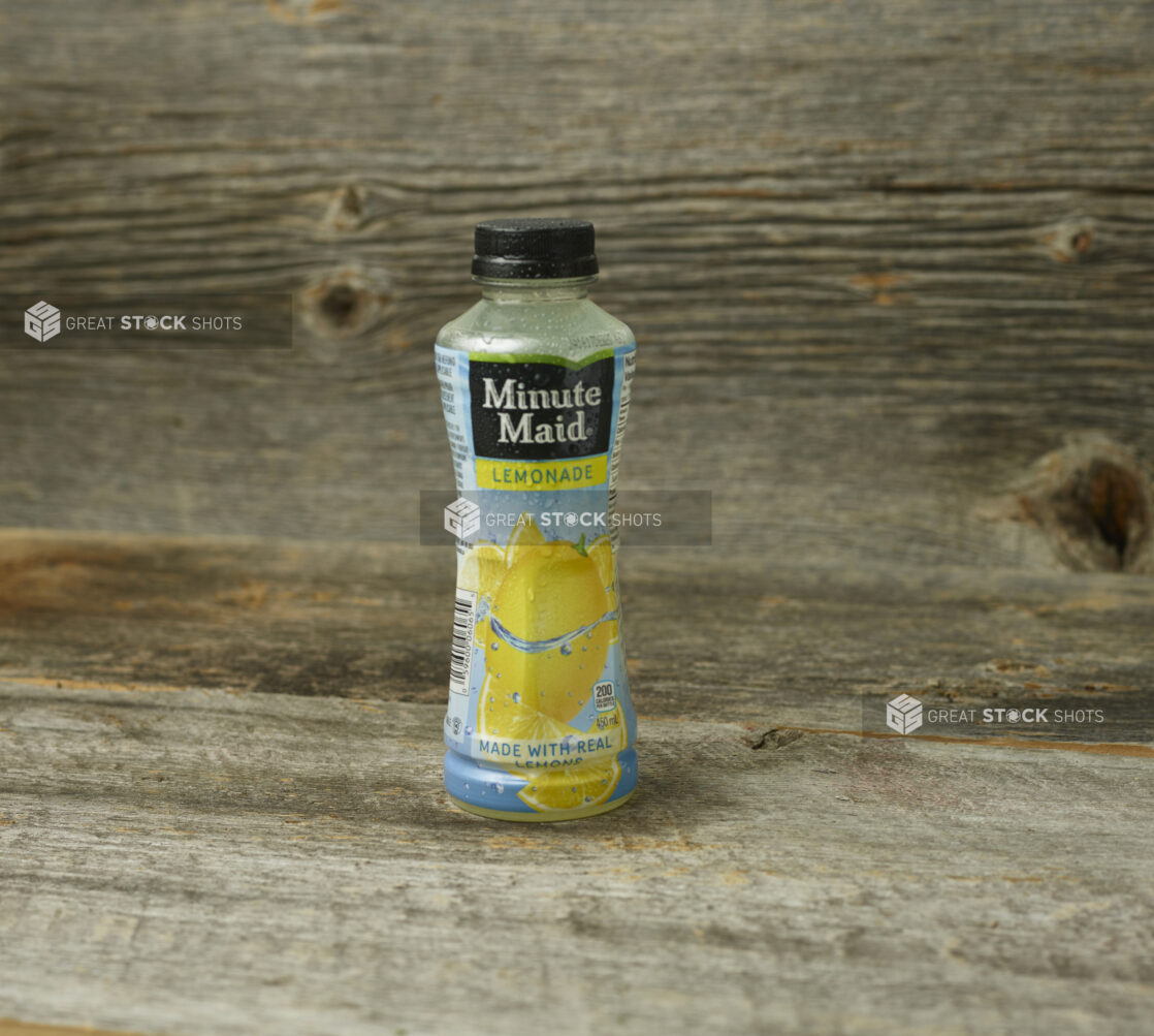 Minute Maid Lemonade in a plastic bottle on a wooden table with a wooden background and a straight on view