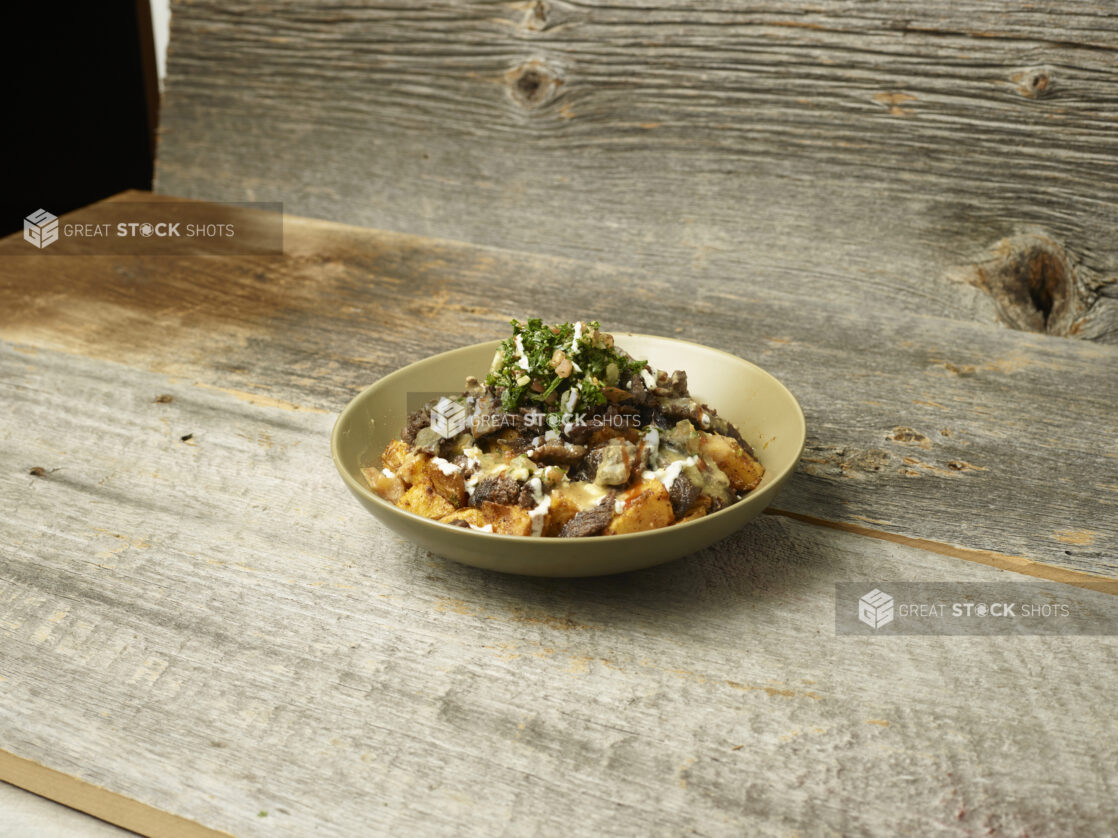 Beef Shawarma bowl on a wooden table with a wooden background