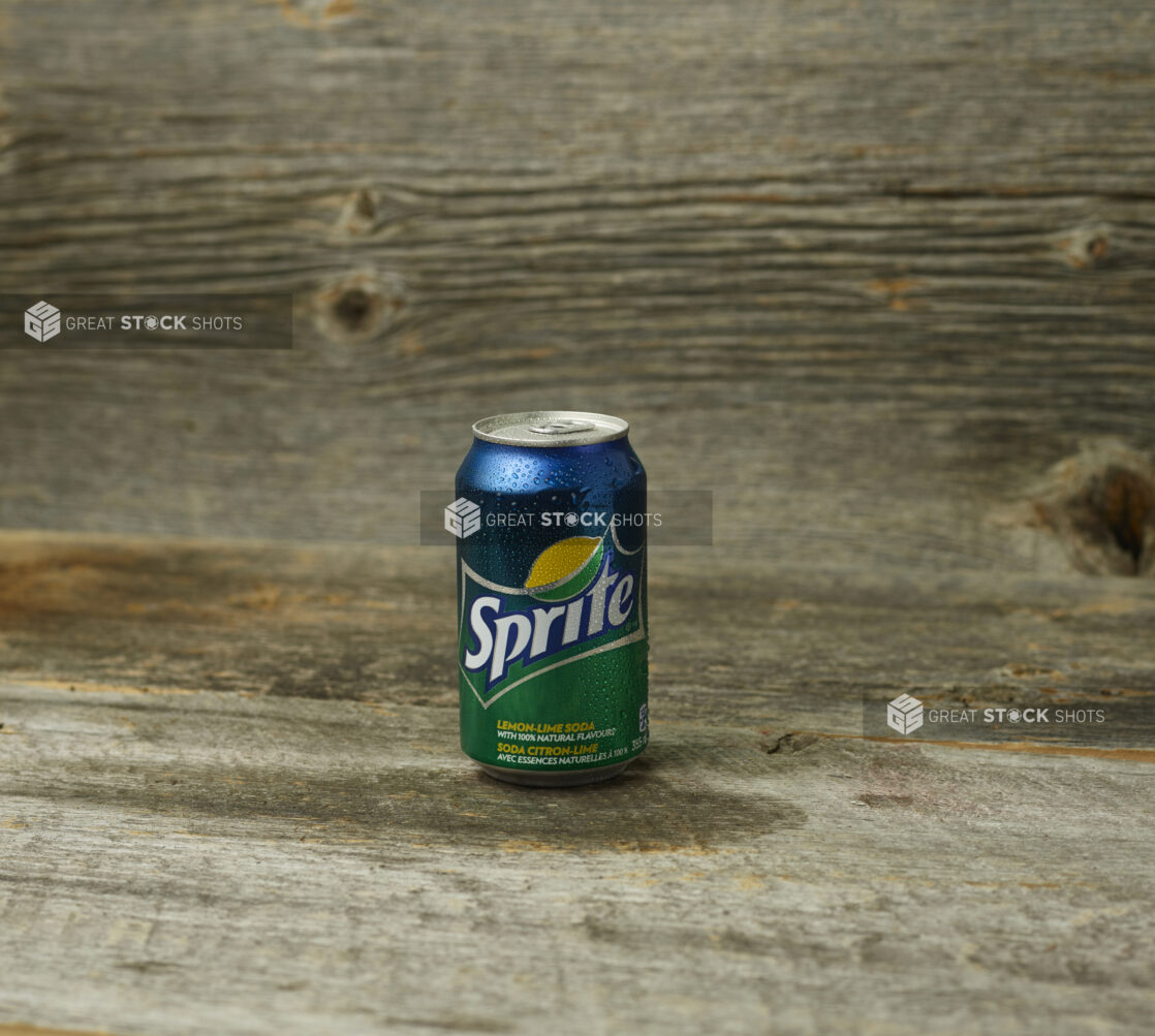 Can of Sprite on a wooden table with a wooden background and straight on view