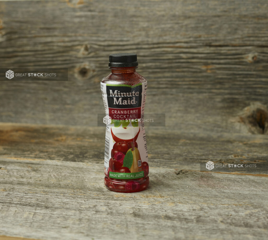 Minute Maid cranberry cocktail in a plastic bottle on a wooden table with a wooden background