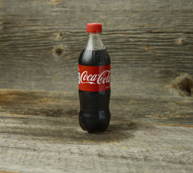 Coca-Cola plastic bottle on a wooden background with straight on view
