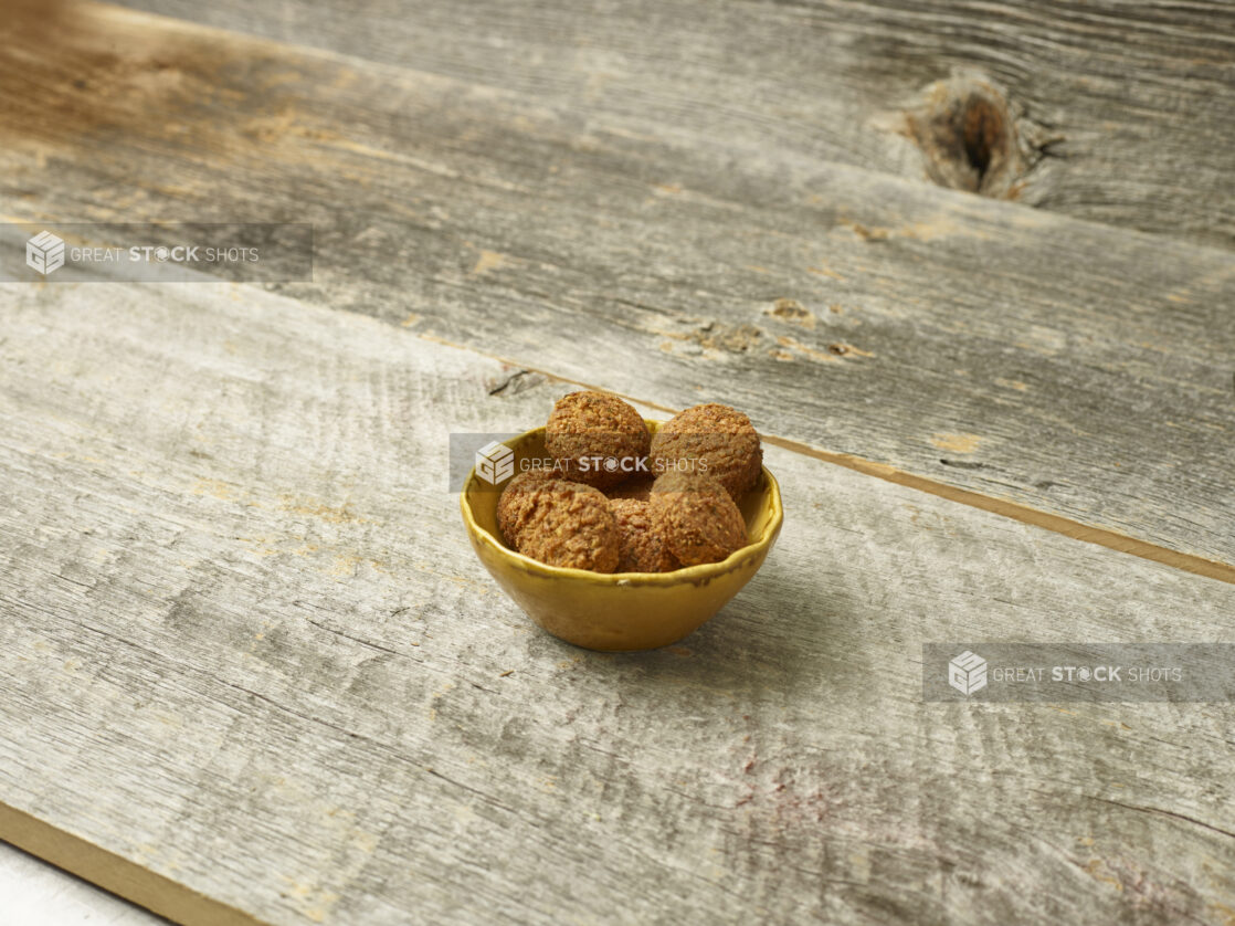 Falafel in a bowl on a wooden table angled