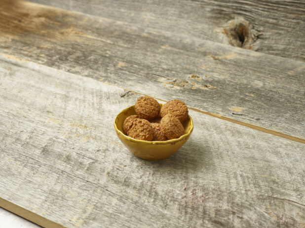 Falafel in a bowl on a wooden table angled