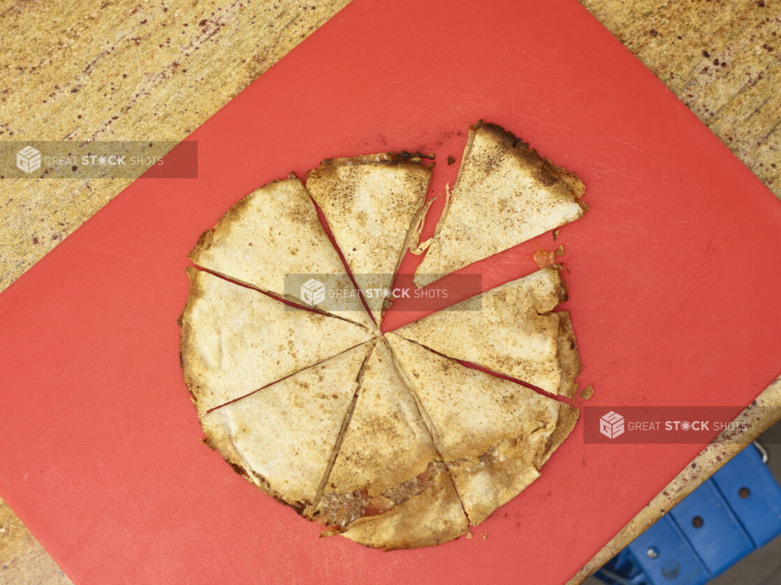 Overhead view of a Lahmajeen/Middle Eastern pizza on a red background